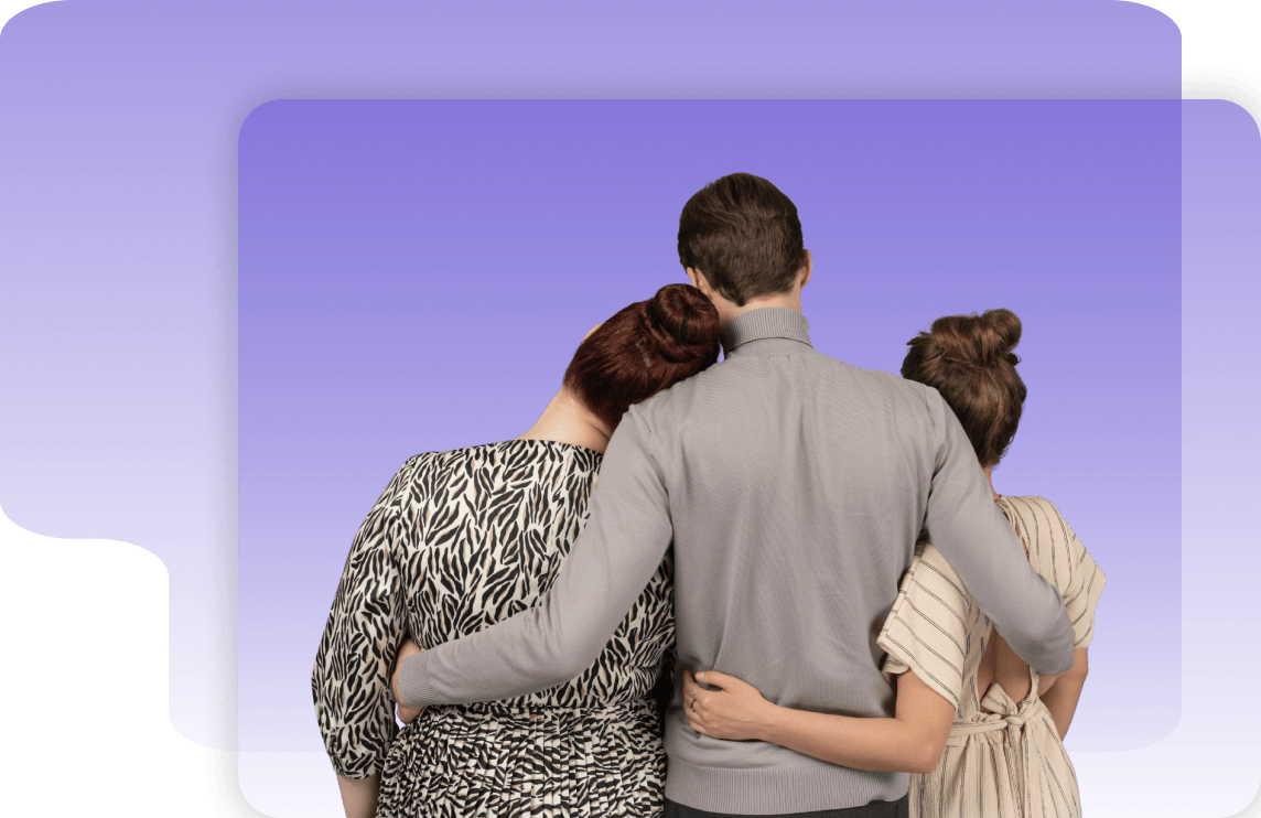Three people stand with their backs to the camera, arms around each other, against a purple background—united as they look forward to new solutions together.